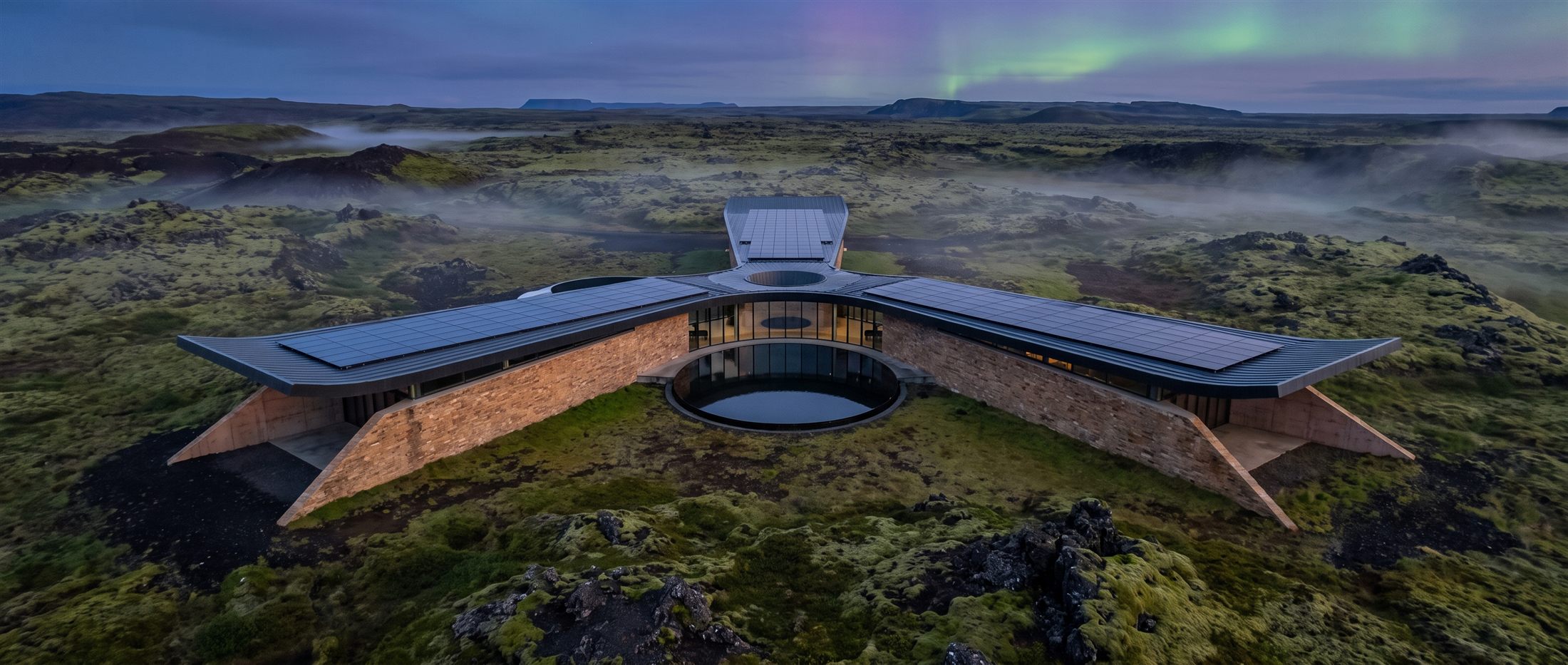Aerial view of Nexus Pavilion's three-wing pinwheel plan around its courtyard, Icelandic highlands